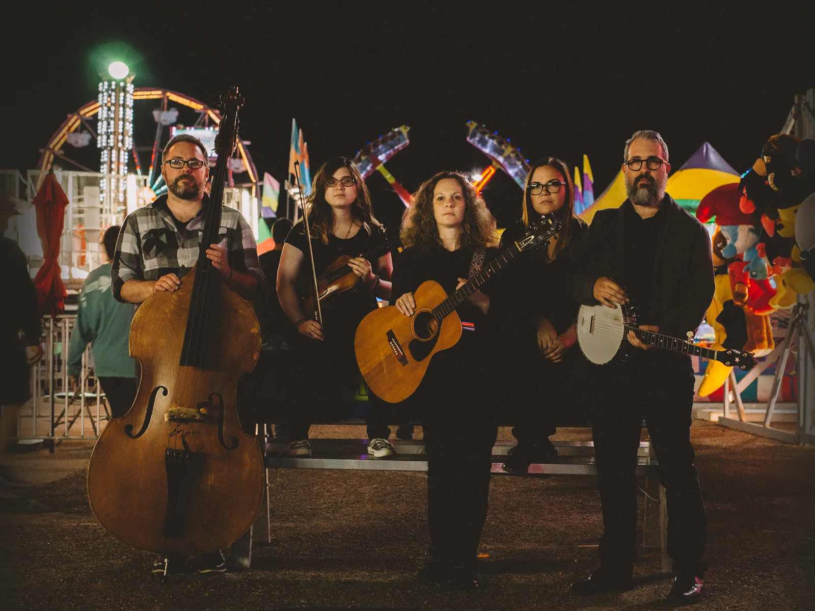 Five members of The Scrips posing at a carnival